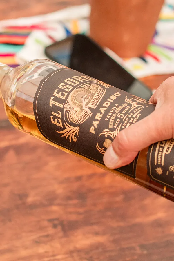 persons hand puring a glass of el tesoro paradiso